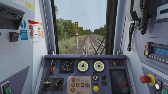 best train games: the inside of a train showing off the main panel and a window showing the main track