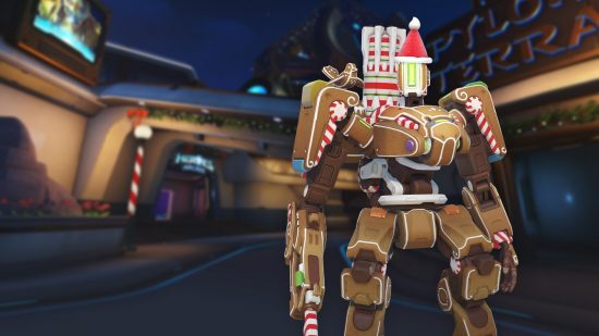 Overwatch 2 Gingerbread bastion skin: Overwatch 2's robotic tank, Bastion, shown in gingerbread form with a red gumdrop Santa hat
