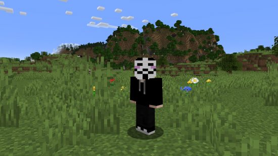 Best Minecraft skins: A hacker skin stands in a filedfield, wearing a black hoodie and a creepy mask.