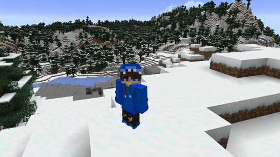 Best Minecraft skins: A Minecraft player stands int he snow in a blue hoodie skin, with the hood up.