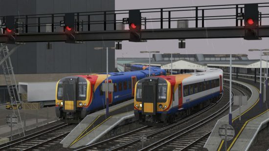 Two South West trains at a platform in the rain in one of the best train games, Train Simulator. They're being held at a red signal.