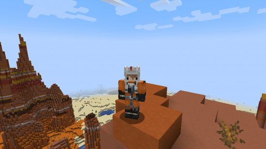 A player wearing a Luke Skywalker Minecraft skin, resembling his orange pilot suit, stands atop a high peak in a badlands biome.