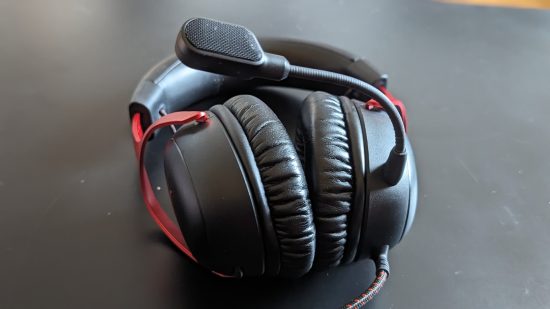 HyperX Cloud 3 review: a headset rests on a black table with its microphone pointing skywards.