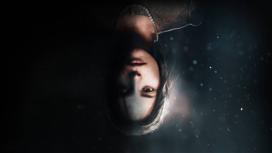 A young woman pictured upside down on a black background that fades into a blue underwater setting