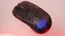 The Cherry XTRFY Mz1 wireless mouse on an orange RGB lit table