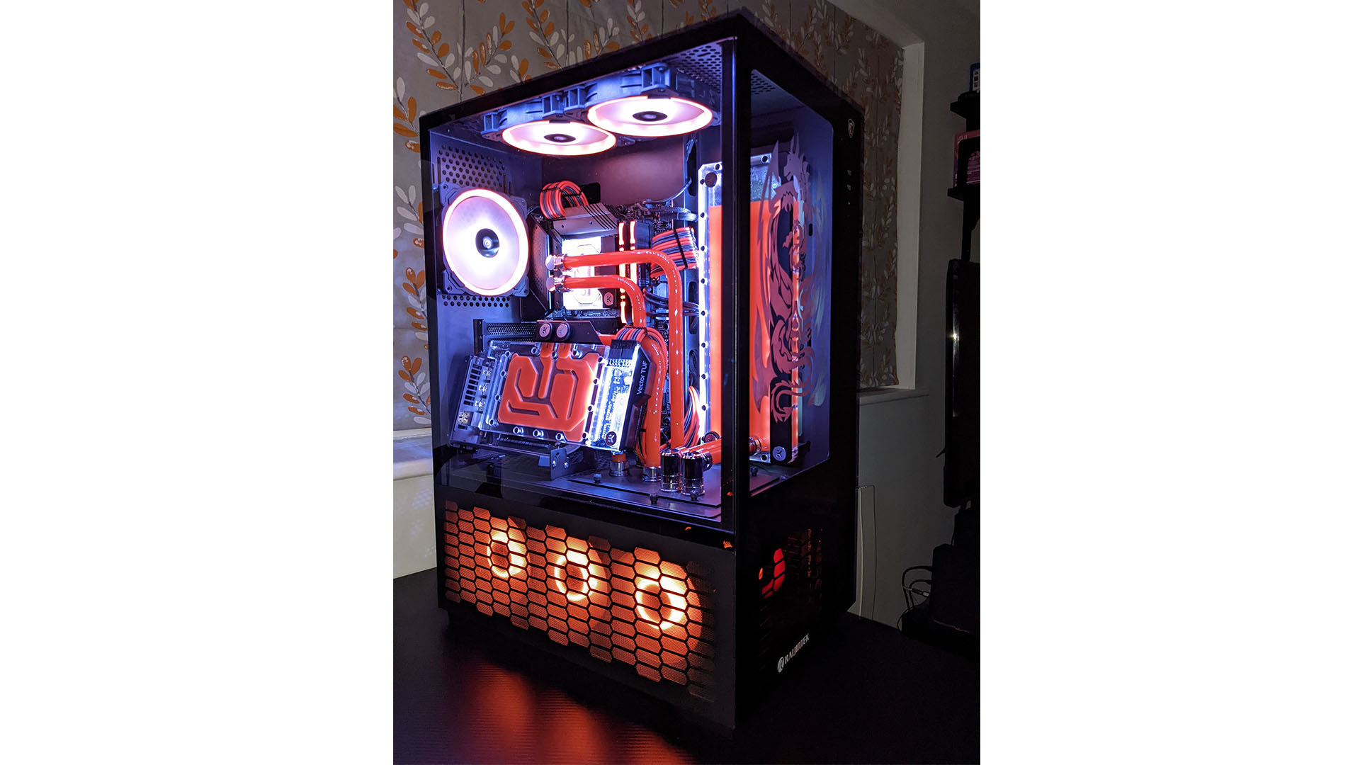 The gaming PC with red fans at the bottom and an angled graphics card