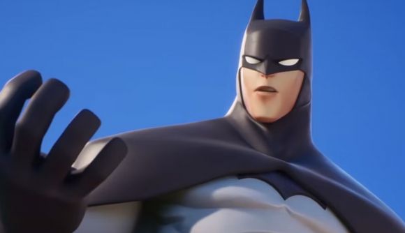 Is MultiVersus down? Server status and launch issues explained: Batman from MultiVersus stands with one hand raised against a blue sky.