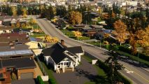 Cities Skylines 2 economy patch suddenly delayed just before launch: A cozy little house sits in suburbs with the city rising up behind.