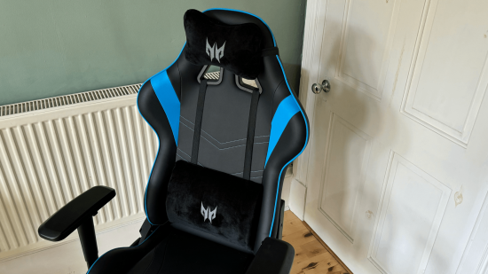 A black and blue gaming chair with detatchable lumbar and neck support