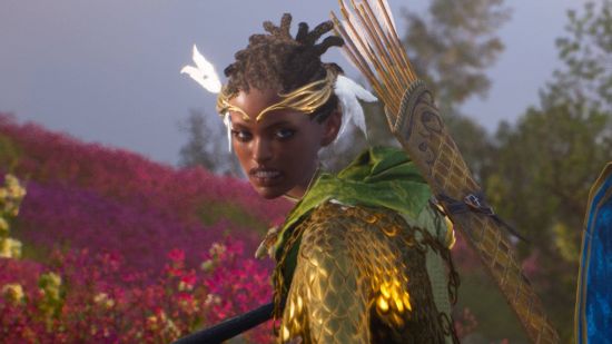 A black woman wearing a golden circlet, with golden armor, a green cape, and a quiver on her back looks into the camera