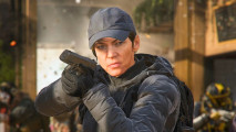 MW3 Game Pass: A woman in a black coat and cap aims a pistol