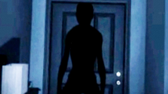 Phasmophobia price increase - A person-like shadow falls across a door in a dark house corridor.