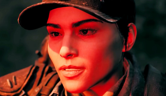 The next Remnant 2 DLC is delayed, but its most expansive yet - A woman wearing a baseball cap, her face awash in red light.