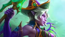 A purple-skinned elf woman wearing a purple witch hat with golden trims raises a glowing green sword with an eye melded into it, looking off camera and smirking