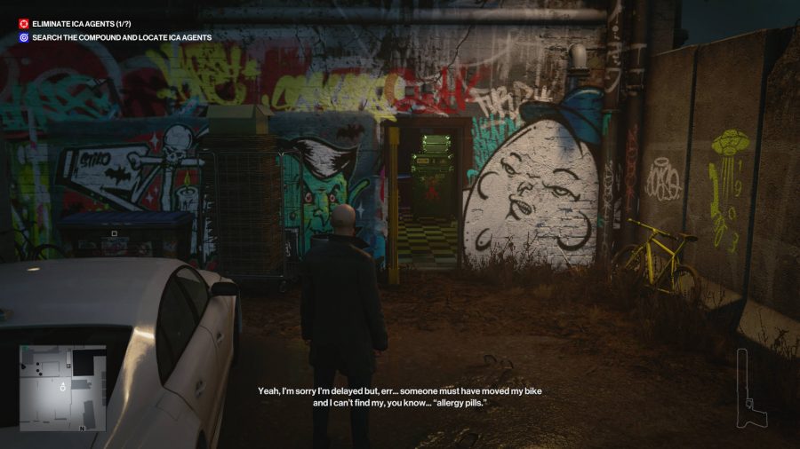 Agent 47 is standing outside, looking at a wall covered in graffiti.